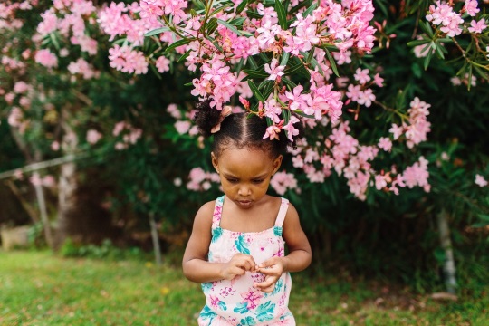 child looking at flower